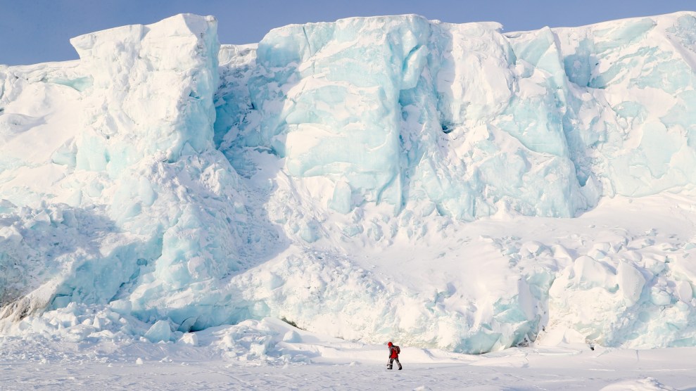A man walks on a glacier in the Arctic.