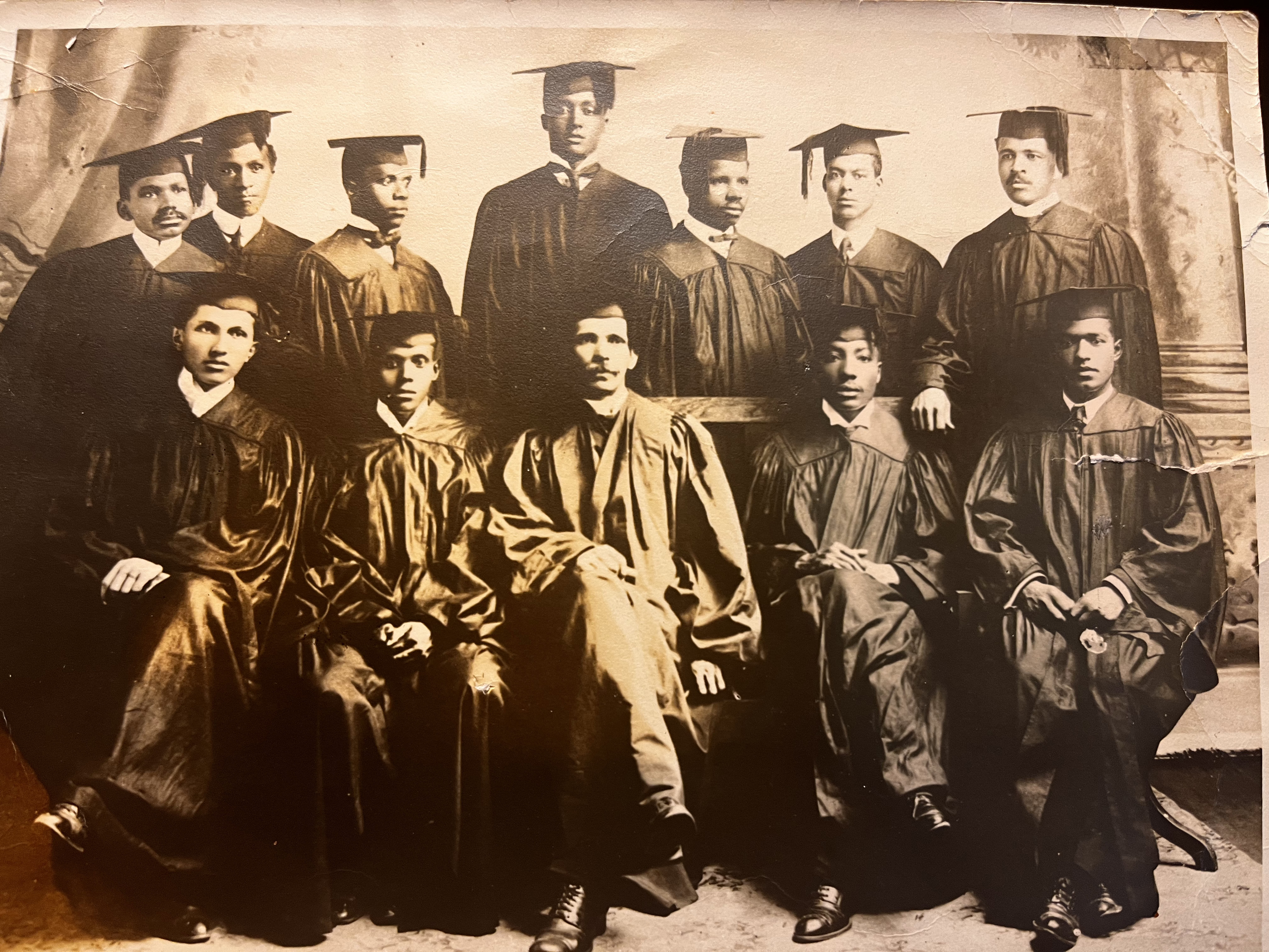 A black-and-white photo of a group of graduates in caps and gowns.
