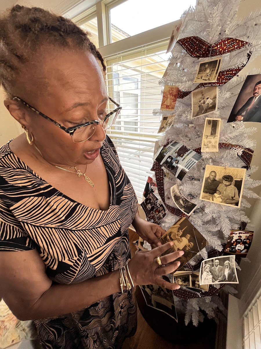 A woman in glasses showing preserved family photos.