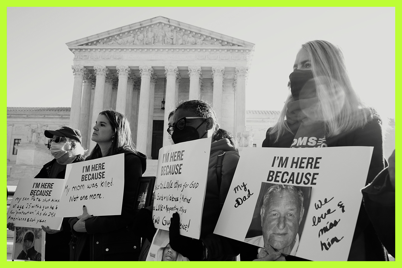 Protesters stand outside the Supreme Court holding signs of remembrance for victims of gun violence.