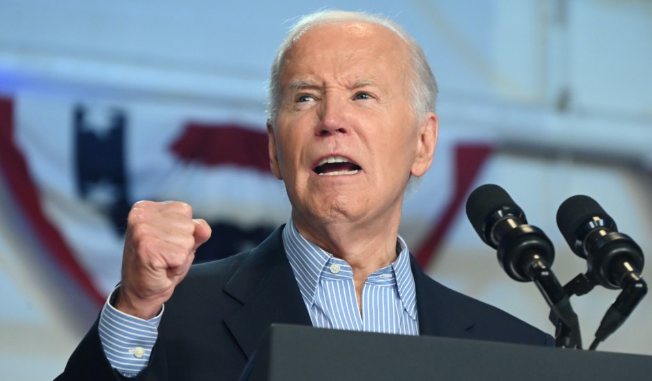Biden speaks at a podium, his fist in the air