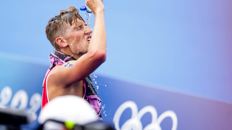 Tjebbe Kaindl, an Austrian triathlete pours water on his face after his race in the Paris 2024 Olympics.