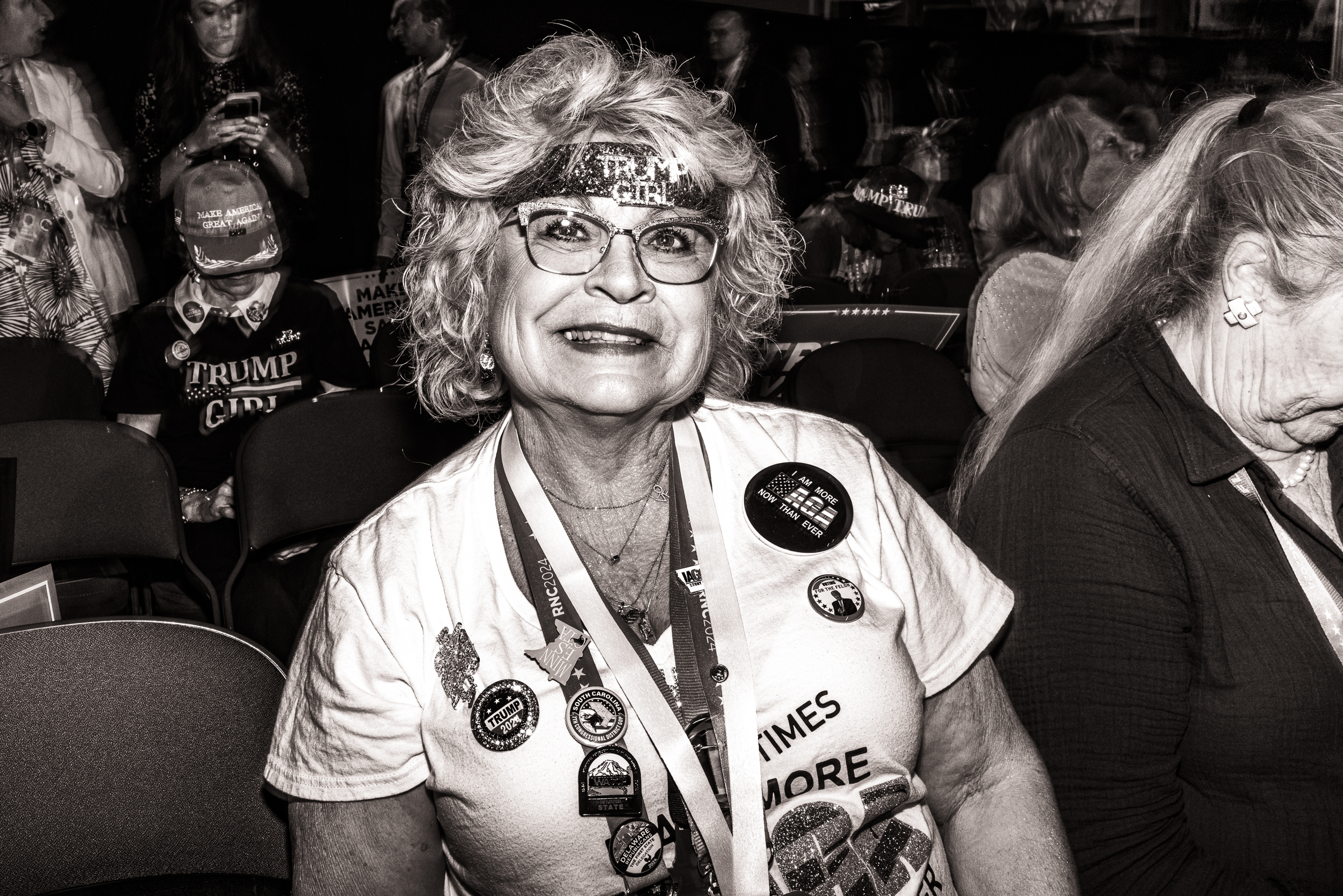 Black-and-white photo of a woman smiling. She's wearing a glitter headband that says, 