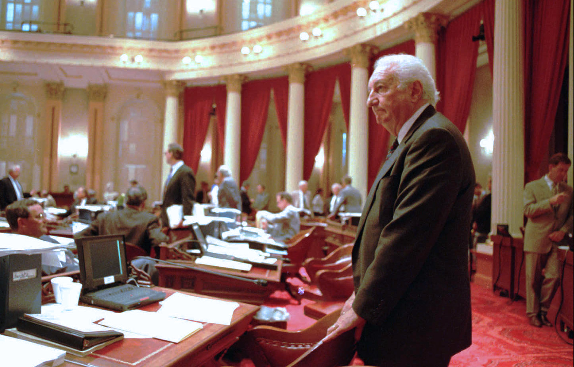 Man standing at a desk in the California legislature.