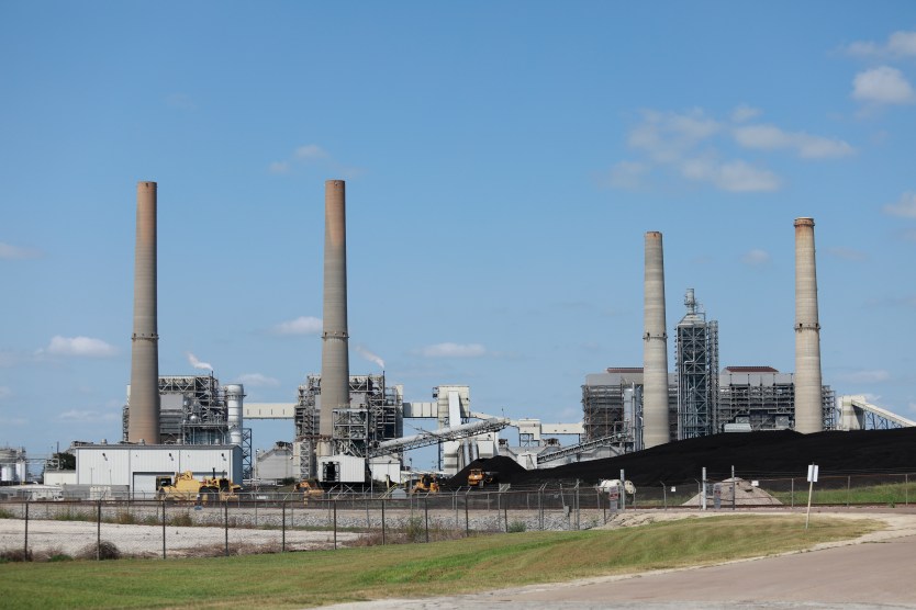 Smokestacks next to a blue sky.