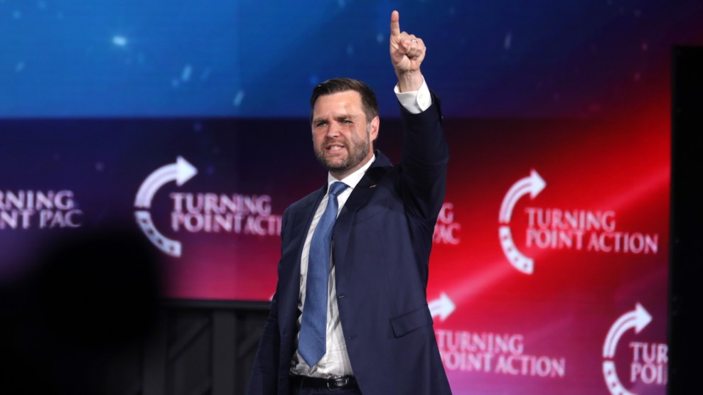 JD Vance points up with his left hand at a campaign rally.