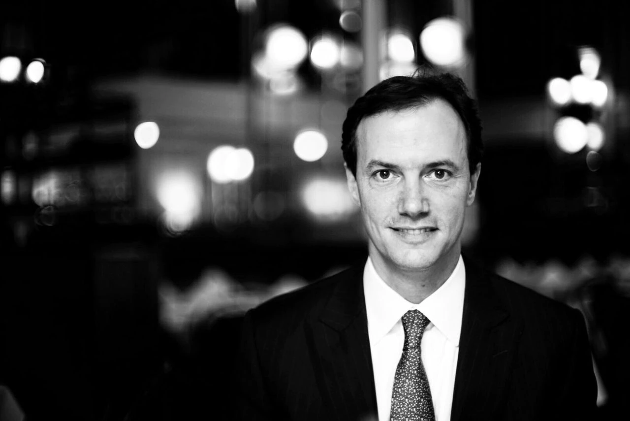 Black and white photo of man in suit smiling.