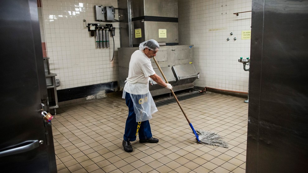 A man with a hairnet mopping a tiled floor.