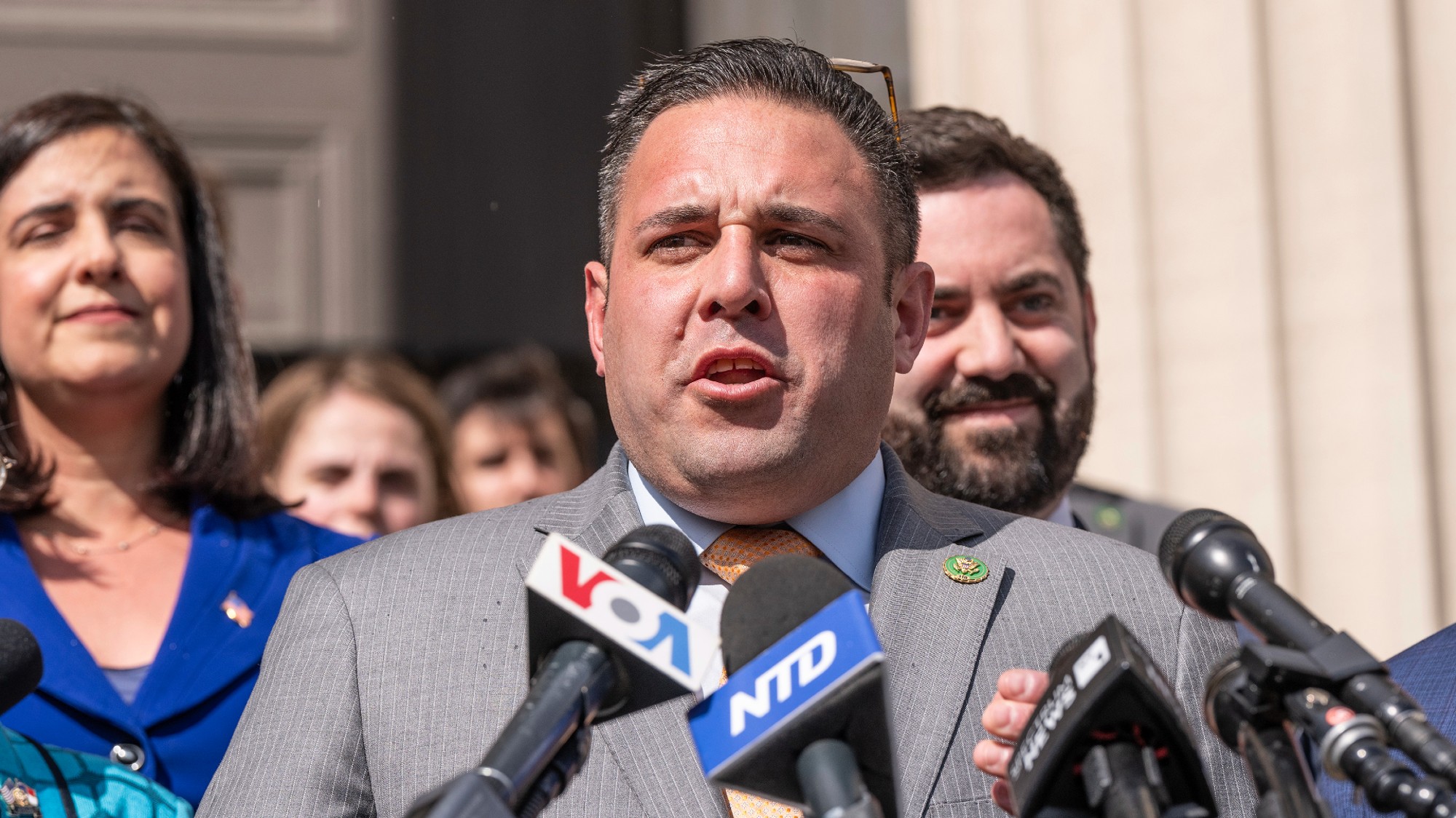 Anthony D'Esposito talks behind a podium at a outdoors press conference.