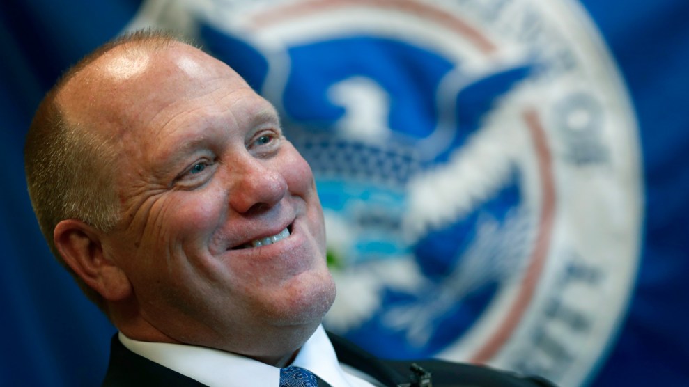 A close-up of Tom Homan grinning smugly