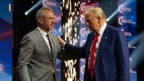 Donald Trump greets Robert F. Kennedy Jr. on a stage.