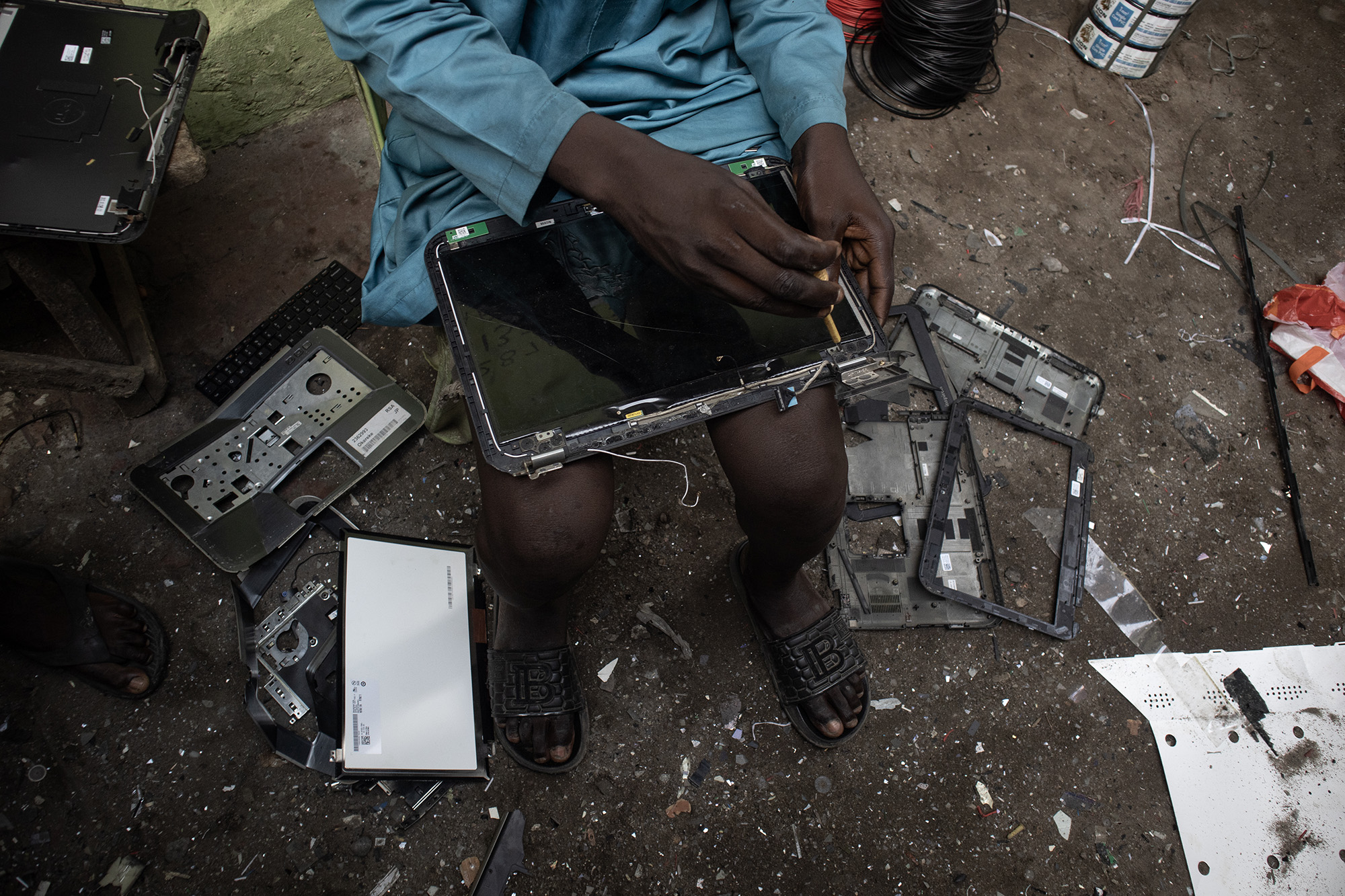 Disassembled laptop screen on a man's lap. 