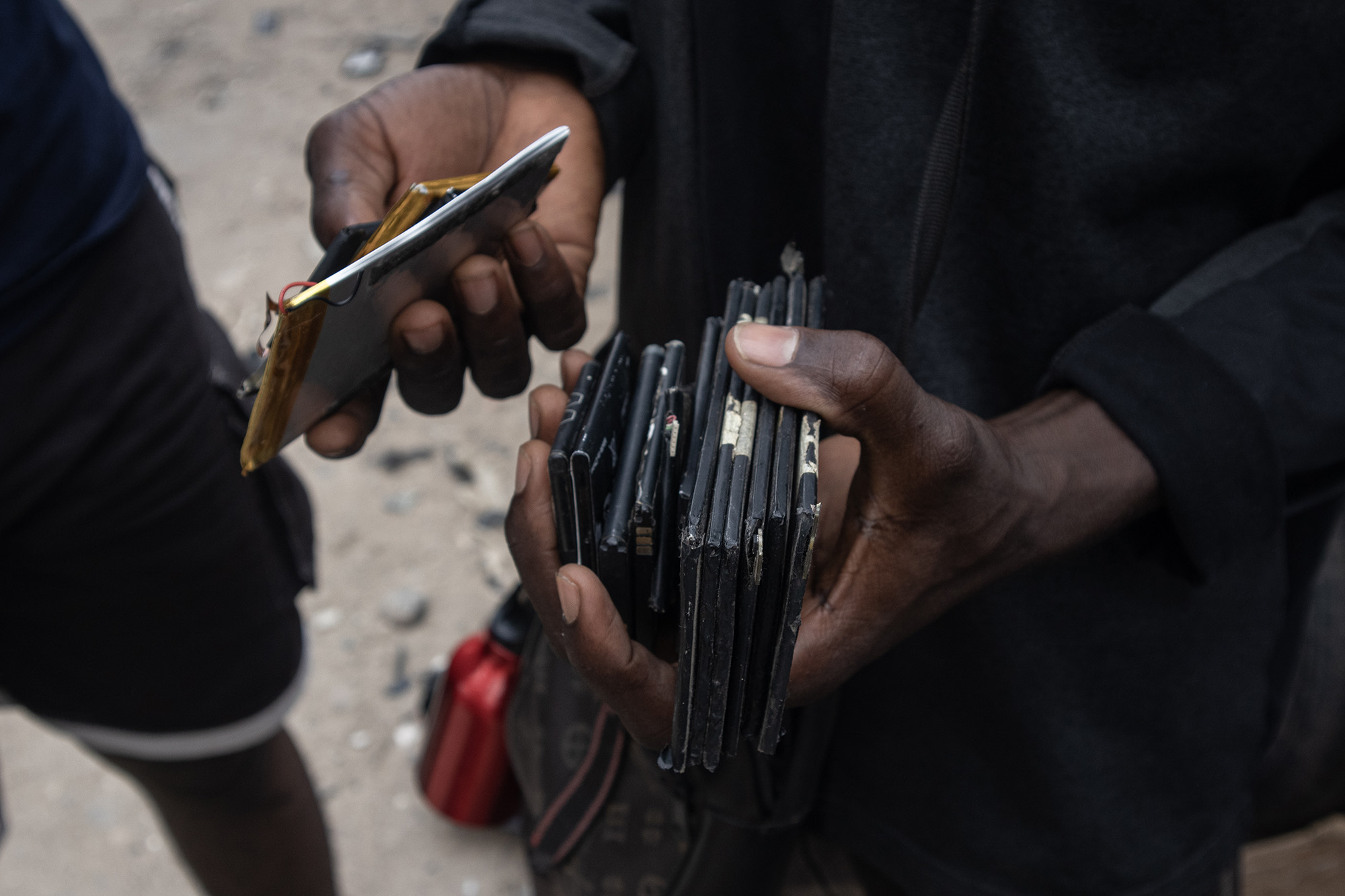 Man holding a stack of lithium batteries for cellphones.