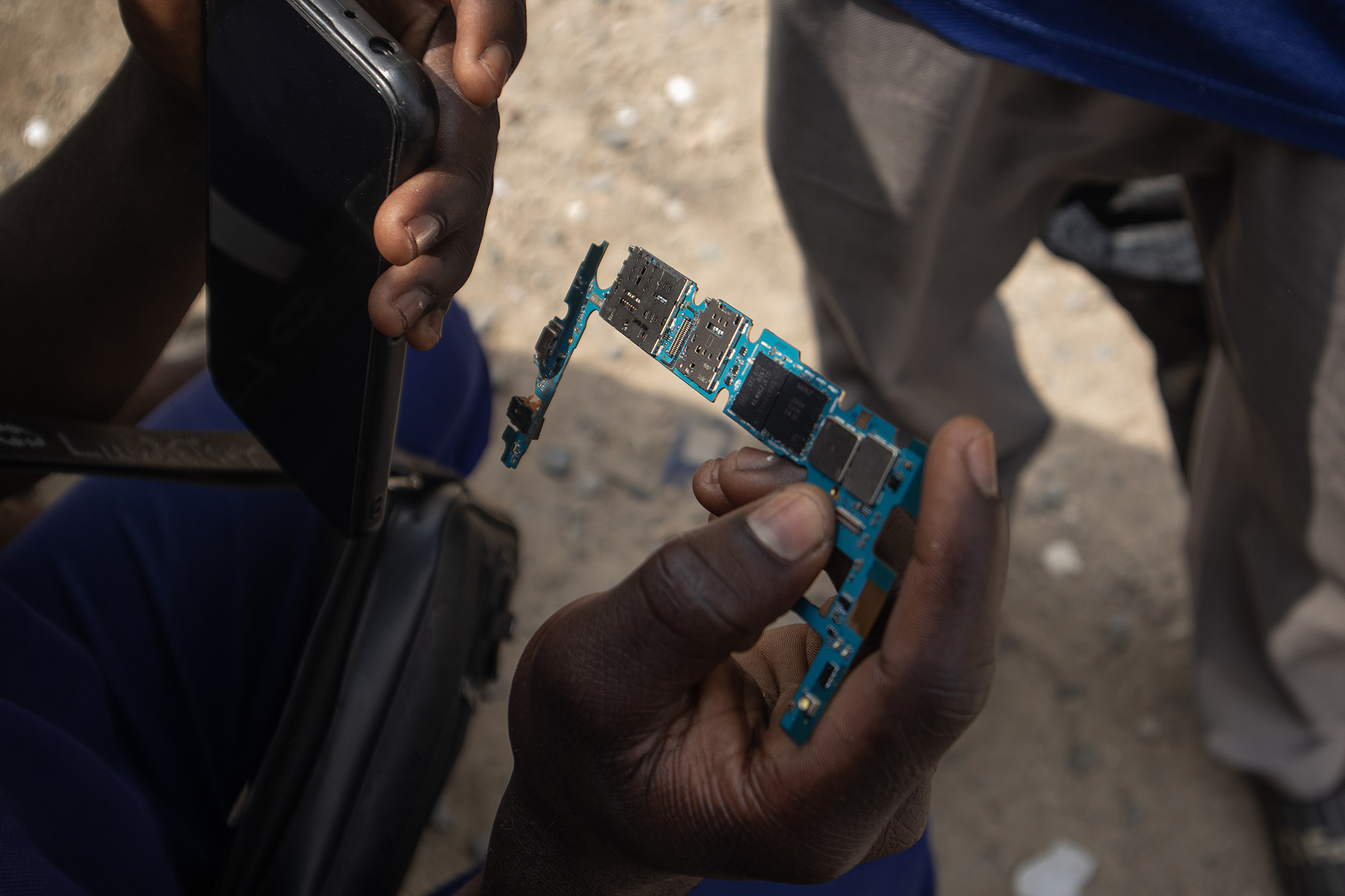 Man holding a circuit board from a cellphone.