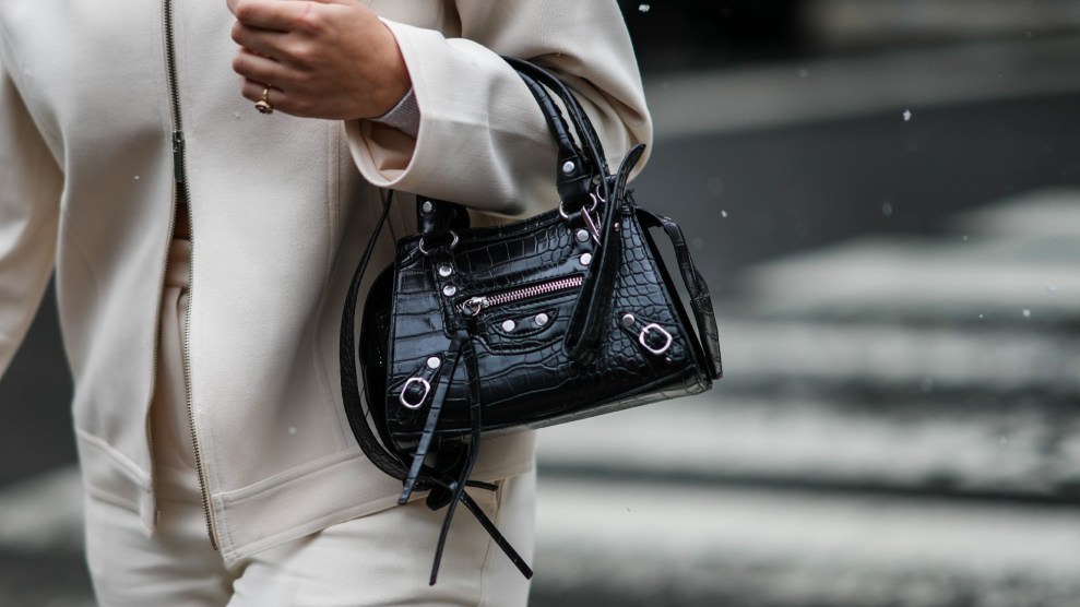 A person holds a small black handbag