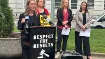 North Carolina's Democratic Party chair speaking at a podium with a sign that says, "Respect the Results."