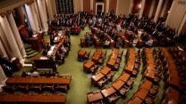 inside the minnesota state house, half of the room is empty, other half is populated by lawmakers