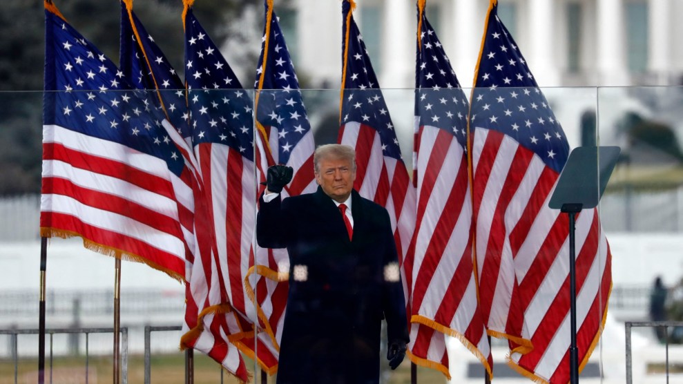 Trump raises his fist on January 6, 2021, in front of American flags