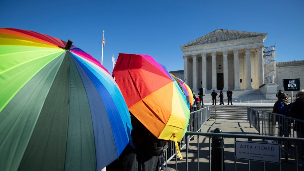 People hold rainbow umbrellas outside the US Supreme Court building.