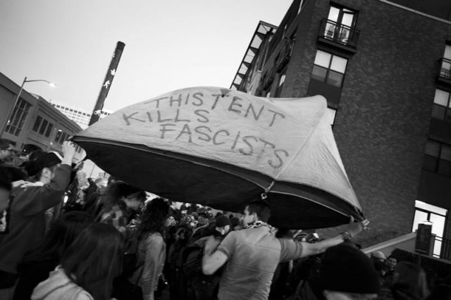 Occupy protesters carry a tent as they march through downtown Oakland.