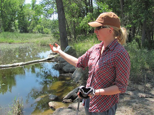 Alexis Bonogofsky points to a pool of oily water left behind on their farm.
