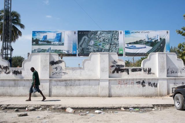 A Haitian walks past government plans for reconstruction at ruined Fort National, Port-au-Prince