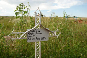 David de la Fuente's humble, hand-painted grave marker is adorned with a simple iron cross.