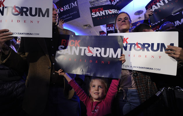 holds up a placard during a caucus night event of U.S. Republican presidential candidate, former Pennsylvania Senator Rick Santorum, in Johnston near Des Moines, capital of Iowa, the United States, Jan. 3, 2012.: Zhang Jun/Xinhua/Zuma