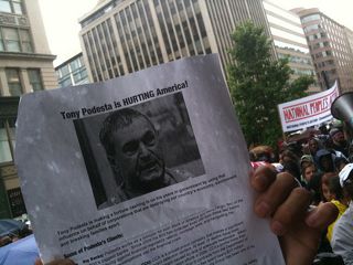 A protester holds up a flier criticizing Tony Podesta, the head of a top Washington lobbying firm. Flickr/movementvision